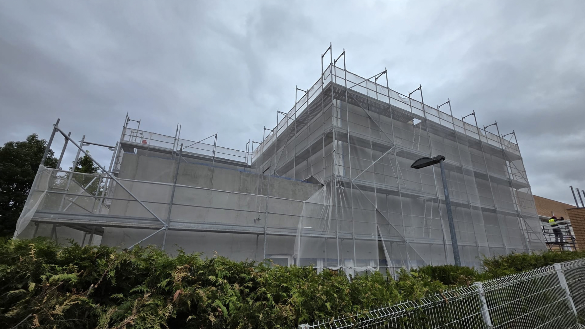 Edifício em obra protegido por andaimes e rede